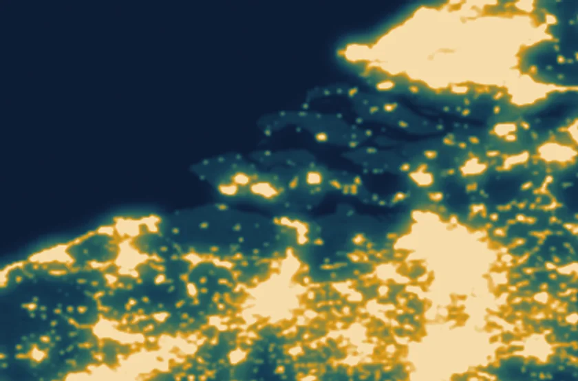 Uitsnede over Zeeland: de eilanden liggen donker tussen het water, met de lichtgloed van Antwerpen aan de onderrand.